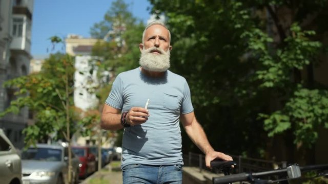 Male vaper with bicycle dreaming while walking