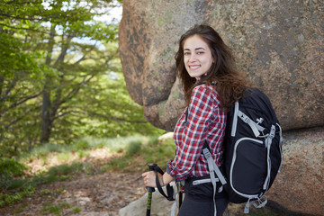 Fototapeta na wymiar Woman hiker smiling and walking with hiking poles. 
