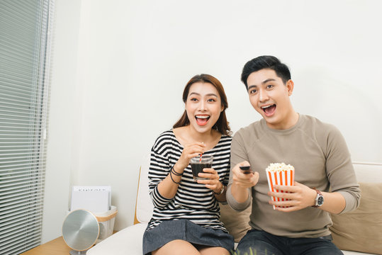 Relaxed young couple watching television in their living room