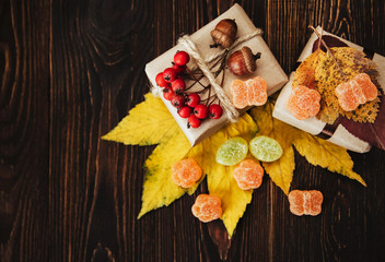 Gift boxes with autumn decorations on wooden background. Top view.