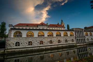 Beautiful example of traditional architecture in Ljubljana, Slovenia - Plecnikove Arcade at sunset, reflecting in the waters of river Ljubljanica