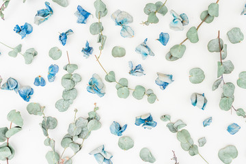 Floral pattern made of blue flowers and eucalyptus on white background, Flat lay, Top view. Floral background.
