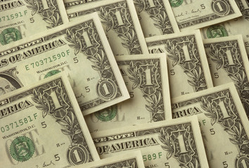 One dollar bills lying on one another