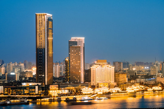 Asoke modern buildings of Bangkok night city skyline, Thailand. Cityscape photography of Benchakitti Park at dusk. Bangkok night city downtown. Modern night city skyline with lights reflection, Asia