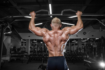 Fototapeta na wymiar Brutal strong bodybuilder man pumping up muscles and train gym