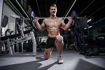 Fototapeta na wymiar Caucasian handsome fitness model training in the gym. Man on diet flexing muscles
