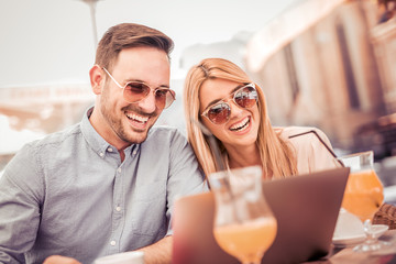 Young couple using laptop in cafe.