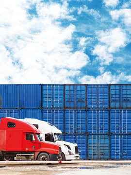 Big trucks on the background of cargo containers. Cargo delivery, logistic, shipping and transportation concept. Blue freight containers on the sky background