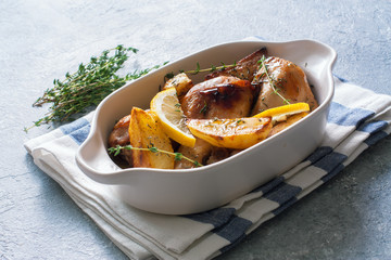 Chicken drumsticks baked with potatoes , lemon and herbs