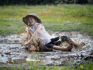 child falls in a puddle. Field. Rural road, mud
