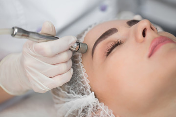 Diamond microdermabrasion, peeling cosmetic. woman during a microdermabrasion treatment in beauty...