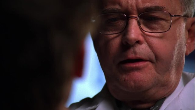 POV closeup of older doctor examining patient.
