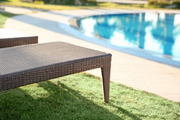 Empty sunbed near swimming pool in luxury hotel