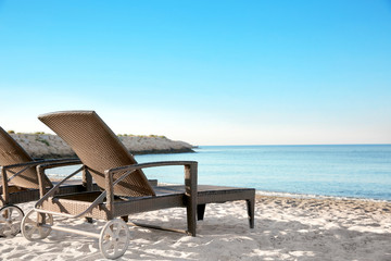 Empty sunbeds on beach near sea