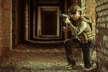 airsoft soldier with a rifle playing strikeball In brick building