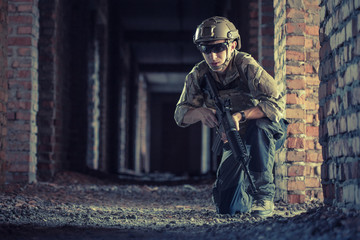 airsoft soldier with a rifle playing strikeball In brick building