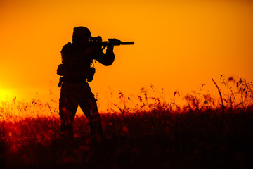 military soldier with weapons at sunset. shot, holding gun, colorful sky. military concept.