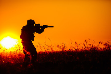 military soldier with weapons at sunset. shot, holding gun, colorful sky. military concept.