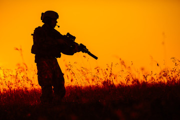 military soldier with weapons at sunset. shot, holding gun, colorful sky. military concept.