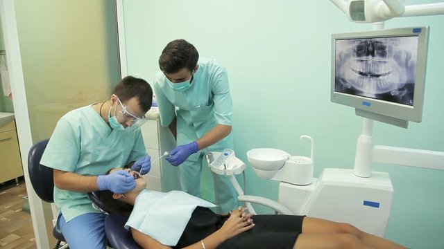 Doctor doing dental treatment to his patient in clinic