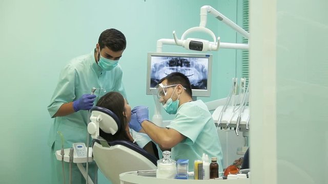 Doctor doing dental treatment to his patient in clinic