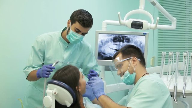 Doctor doing dental treatment to his patient in clinic