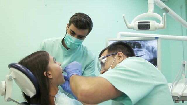 Doctor doing dental treatment to his patient in clinic