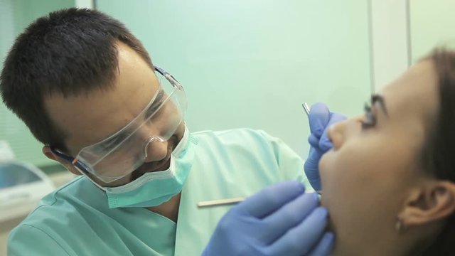 Doctor doing dental treatment to his patient in clinic