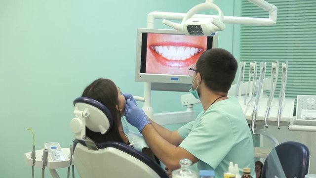 Doctor shows on the monitor the healthy teeth of the patient