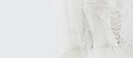 Beautiful white wedding dress and veil on chair