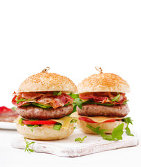 Big sandwich - hamburger burger with beef, cheese, tomato, cucumber and fried bacon.