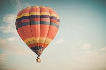 Foto op Plexiglas Ballon Uitstekende hete luchtballon die op hemel vliegt. reis- en luchttransportconcept - vintage en retro filtereffectstijl