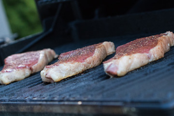 Seasoned steaks on a grill 