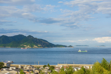 Obraz premium a ship and islands under the blue sky on Setonaikai sea in Ehime, Japan