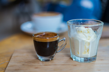 Affogato coffee or espresso with icecream on wood texture and blurred background