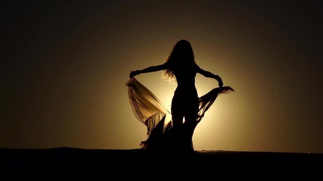 Dancer makes sexual movements with her body. Silhouette. Slow motion