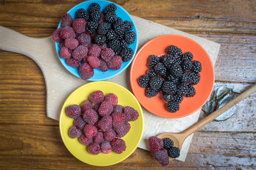 Fresh berries blackberry and raspberry on a plate in vintage style