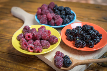 Fresh berries blackberry and raspberry on a plate in vintage style