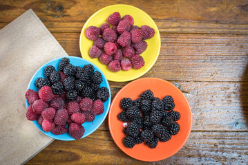 Fresh berries blackberry and raspberry on a plate in vintage style
