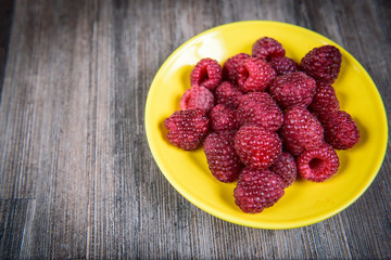 Healthy raspberry fresh organic fruit on a wooden table in vintage style