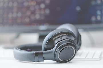 Obraz na płótnie Canvas macro over-the-ear bluetooth headphones with active noise control on computer keyboard