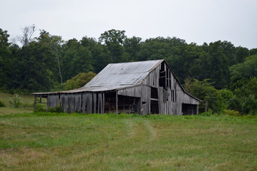 Fototapeta na wymiar Old rundown barn in a field on a farm