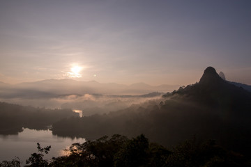 Landscape shot of sunrise in the morning with fog surrounding the mountain