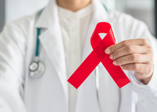 Aids red ribbon in doctor’s hand for World aids day concept and HIV virus awareness concept