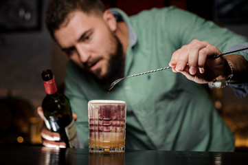 Bartender adds wine to the cocktail
