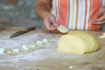 dough for woman's hand making homemade pasta, tortelli