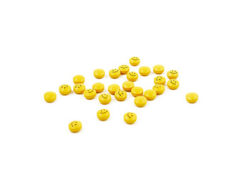 Pills stock images. Yellow pills on a white background. Smileys photo