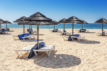 Umbrellas and sunbeds on the southern beach of the Algarve. Portugal.