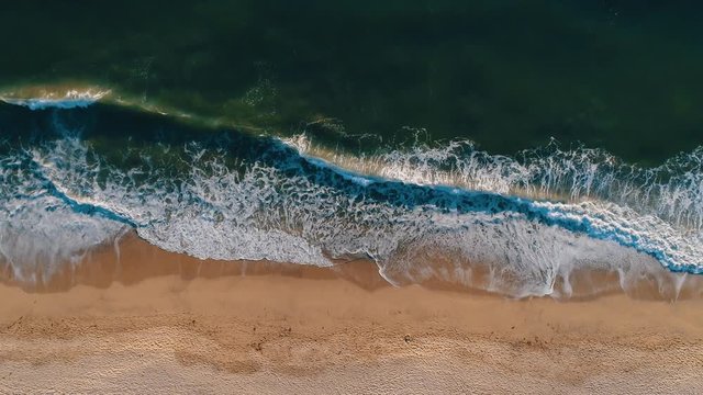 Aerial top shot of sandy golden beach waves and turquoise ocean. Perfect for wordpress website video background or nature travel video