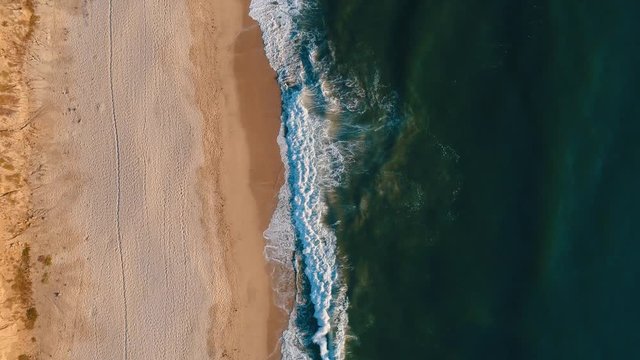 Aerial top shot of sandy golden beach waves and turquoise ocean. Perfect for wordpress website video background or nature travel video